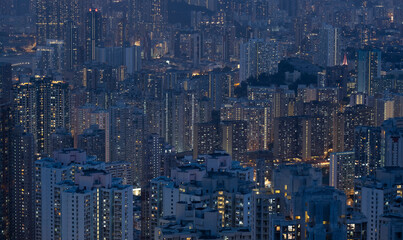 Crowded city with lights turning on and off at night. Hong Kong city apartment buildings at night. 