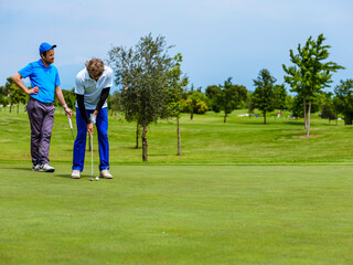 Fototapeta premium The golfer hits the ball with a putt