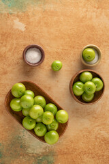 fresh ripe green plums on a table served with salt