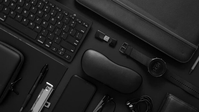 Business concept. Flat lay composition with various black gadgets on dark black surface