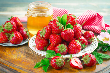 Ripe, fresh strawberries in a bowl on an old background.