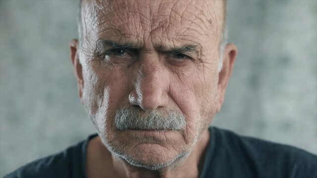 Angry old man portrait. Face of elderly senior guy, serious face looking to camera, close up face portrait.
