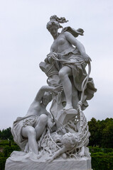Obraz premium Ancient statue in the city park of two sensual Renaissance Era women catching a child by fishing net from sea, Potsdam, Germany