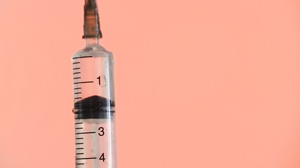 Doctor open needle and sprinkling medicines on a pink background