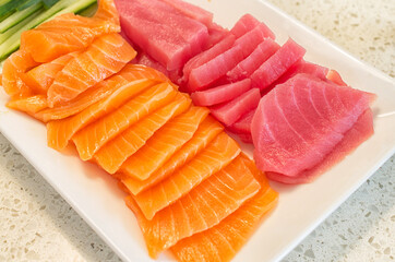 Dish full of sliced salmon and tuna ready for Japanese sashimi
