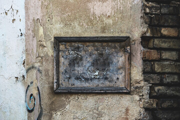 Old weathered wooden frame on brick wall covered with plaster