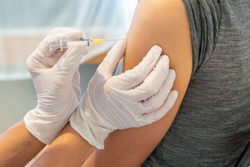 horizontal view of female doctor vaccinating a female patient