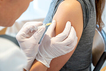horizontal view of female doctor vaccinating a female patient