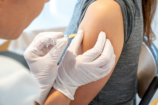 horizontal view of female doctor vaccinating a female patient