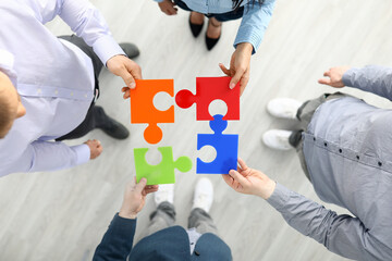Group businees people hold color element puzzle top view background closeup. Each fulfills its task...