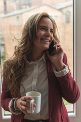 young worker talking on the phone while drinking coffee