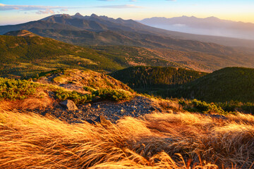 夕焼け色に赤く染まる南八ヶ岳、最高峰の赤岳、阿弥陀岳、横岳、硫黄岳、編笠山。The Yatsugatake mountain range that is illuminated by the setting sun & the blue sky & white clouds during the magic hour .旅行、旅先、シルバーウィーク、紅葉。