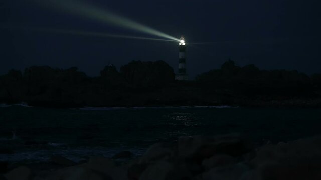 Very powerful Creach lighthouse illuminated in evening, Ushant island, France