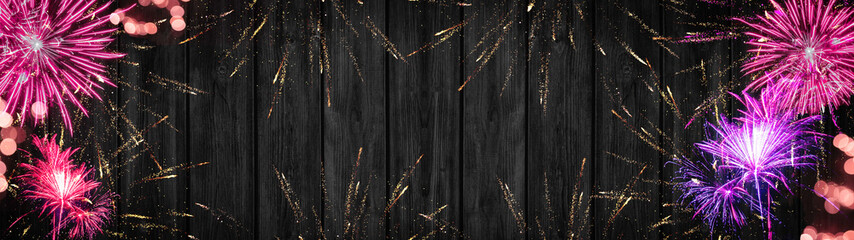 Silvester background banner panorama long- Pink golden firework and pink bokeh lights on rustic dark black grey wood texture, with space for text
