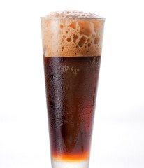 Coke in a glass. Carbonated cold drinks foaming on top after being poured into clear glass.