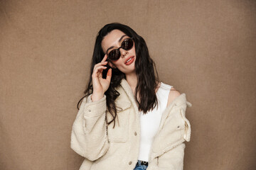 Photo of confident woman in sunglasses posing and looking at camera