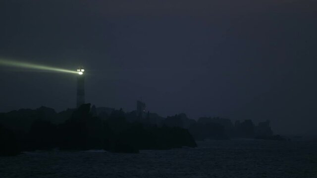 Very powerful Creach lighthouse illuminated in evening, Ushant island, France