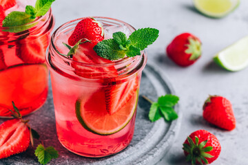 Strawberry lime mojito with fresh mint and ice in glass jar.
