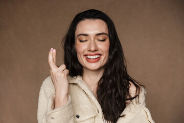 Photo of happy woman laughing and holding fingers crossed for good luck