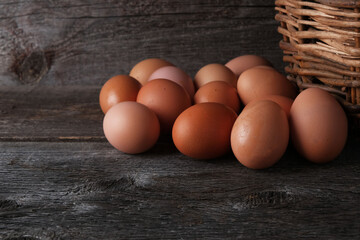 Homemade farm eggs on a wooden background with a basket, copy space, natural products