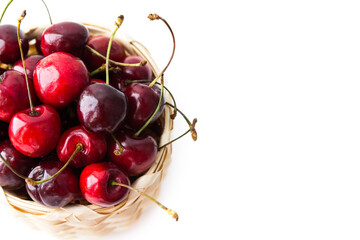 Ripe cherry berries in the basket isolated on the white background. Top view. Selective focus