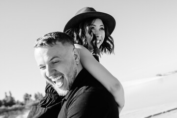 young couple a guy and a girl with joyful emotions in black clothes walk through the white desert