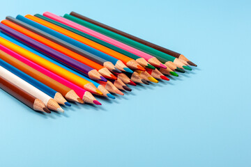 colored pencils isolated on blue background