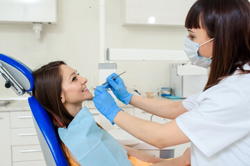 dentist examine the patient teeth with dental instruments in medical clinic.