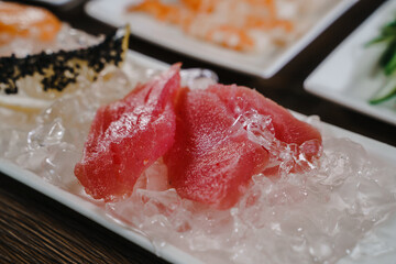 Thin slices of tuna lying on ice chips .Preparing for cooking