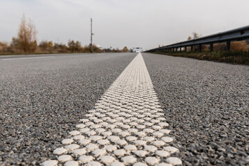 selective focus of lane on grey asphalt on empty highway