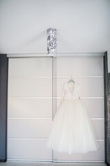 Wedding dress hanging on the door.