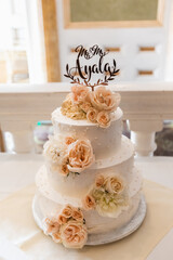 Obraz na płótnie Canvas Wedding cake standing on the table. Around the flowers. Inside.