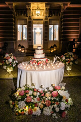 Wedding cake standing on the table. Around the flowers. Inside.