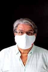 Man studio frontal portrait with mask on. He is wearing prescription glasses. He is looking at the camera.