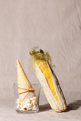 Vegetable corn ice cream with waffle cone on beige textile background.Healthy eating concept.Fashion food composition
