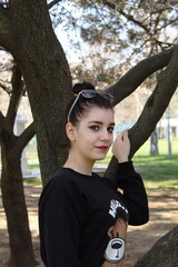 Portrait of a young girl in front of a tree outside