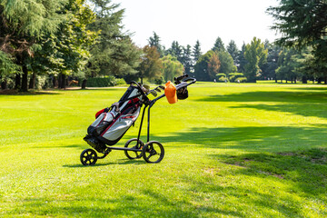 Golf cart with bag and golf clubs on a golf course.