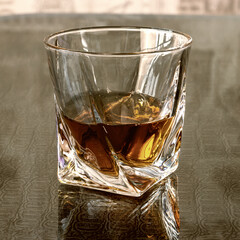 A glass of whiskey is on the table. Tinted photo with filter