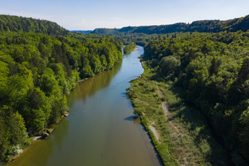 Fototapeta na wymiar Bird view of Isar river comming from the Alps throgh a valley full of forest in spring summer time. Aerial photo of german river south of Munich.