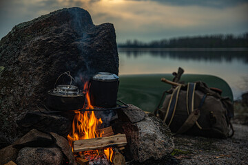 Wilderness landscape, evening campfire by the lake, canoe