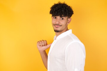 Closeup of cheerful handsome European dark haired blue eyed man looks joyful, satisfied and confident, points at himself with thumb, isolated over gray studio background.