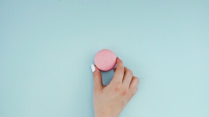 Macaroons or macaron on pastel blue surface. Close up.