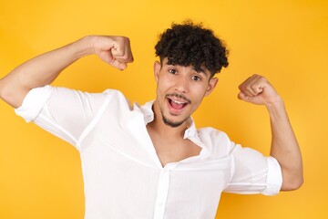 Yes I am winner. Portrait of charming delighted and excited caucasian male student raising up fist in triumph and victory smiling achieving success grinning from delight.