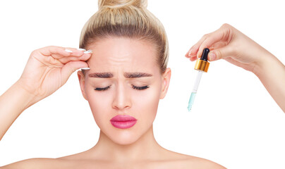 Young woman touches wrinkles skin on forehead near pipette with serum.