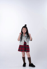 Litttle girl raise fist up beside her body and smile,model posing on background