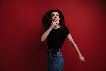 Photo of young surprised woman posing and looking upward