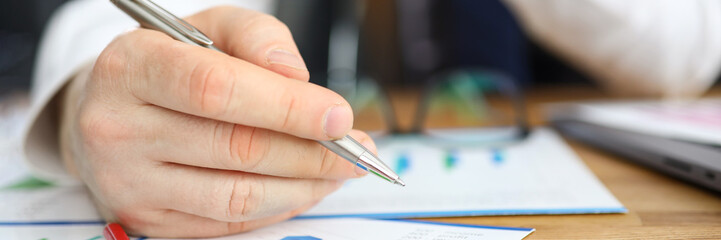 Man makes edits leaning over financial report