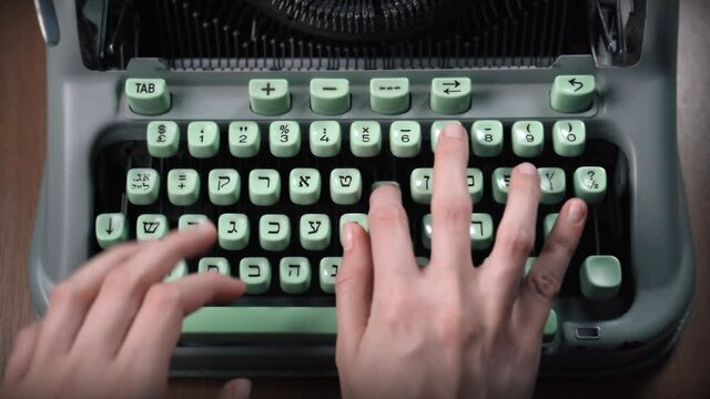 Female hands typing text on an old hebrew typewriter