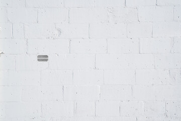 Outdoor shutter at white wall outside of warehouse or factory.