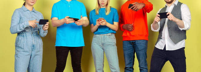 Group of friends using mobile smartphones. Teenagers addiction to new technology trends. Close up. Millenials texting, scrolling, chatting, watching video or shopping online. Connecting with devices.